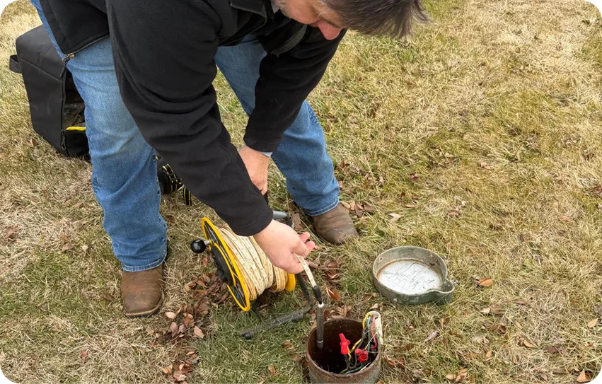 Zynex Technician performing underground utility inspection using cable and access chamber